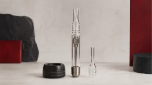 A quartz nectar collector with the full body, removable quartz tip and protective stand visible
