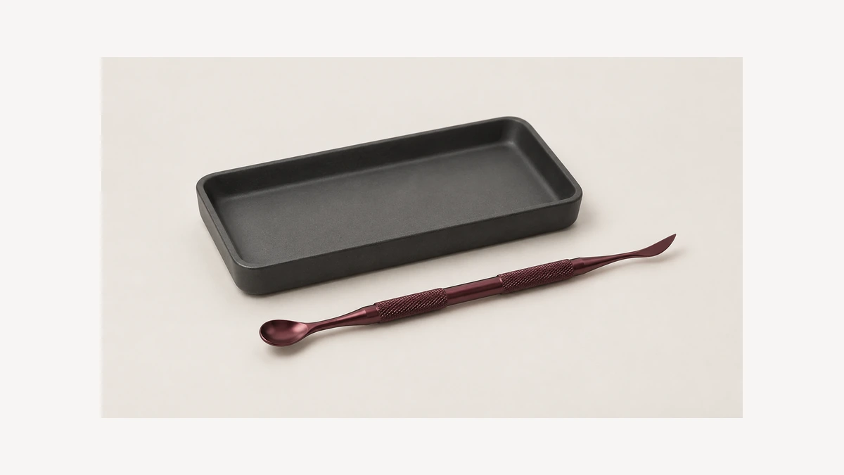 Double-ended scoop and curved point accessory beside an empty tray