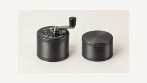 Complete crank-top herb grinder beside a conventional twist-top grinder