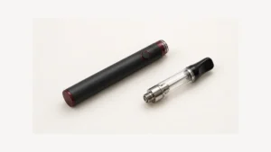 Inactive pen battery beside separate empty oil cartridge with threaded base